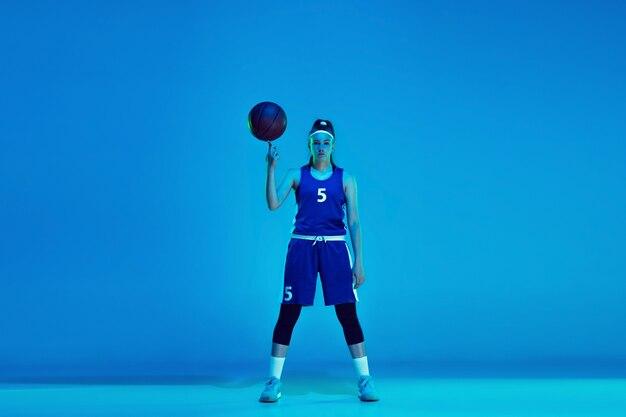 Free photo young caucasian female basketball player isolated on blue in neon light