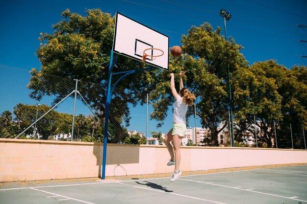 Free photo young woman making basketball jump shot